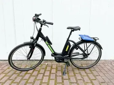 Velo electrique noir avec sacoche bleue sur paves - Cote Baltique Allemagne