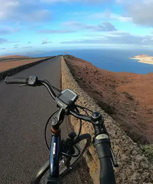 Cycliste sur les routes volcaniques de Lanzarote surplombant la mer - Canaries - Espagne © David Praire