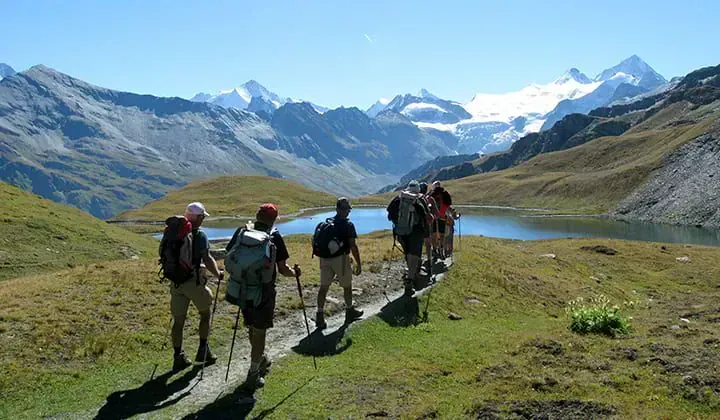 Groupe de randonneurs vers un lac alpin et glaciers - Arolla-Zinal Suisse
