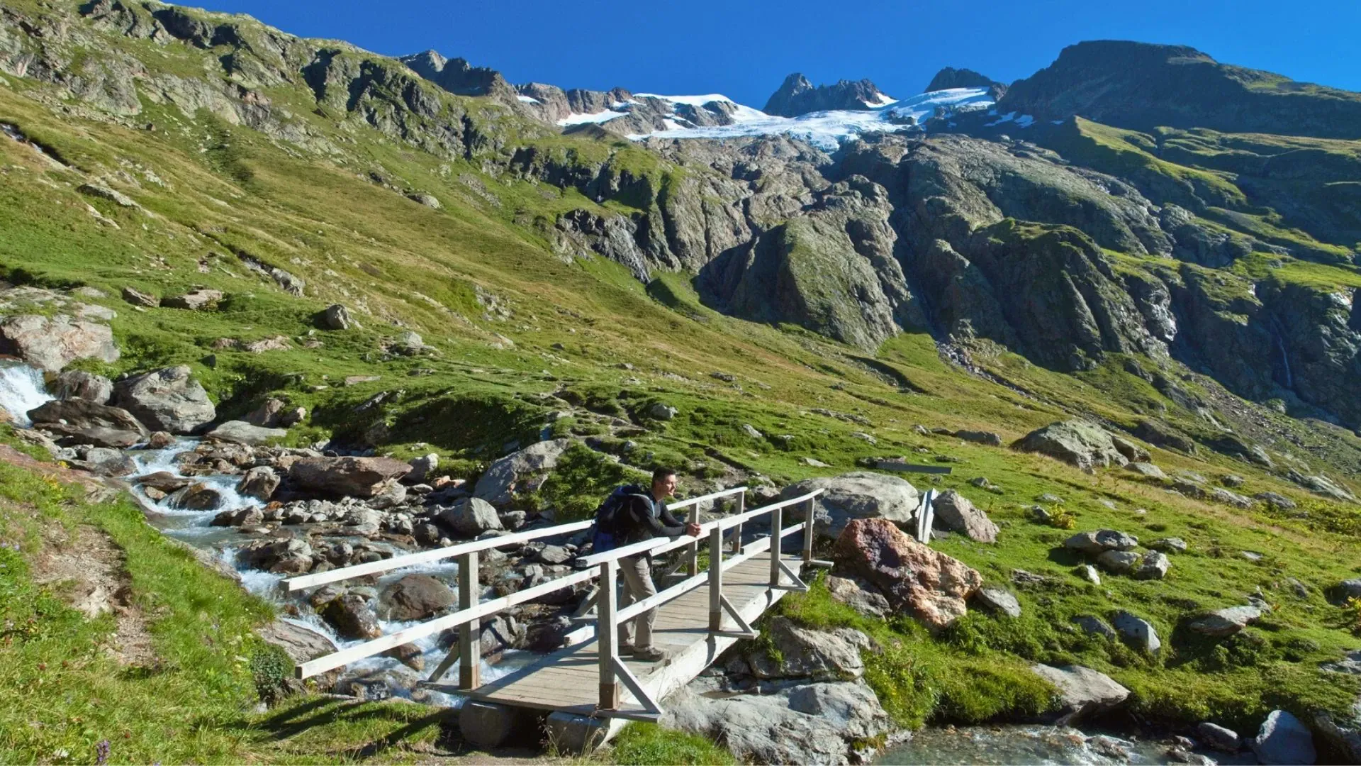 Randonneur traversant un pont de bois pres d'un glacier - Mont Blanc France