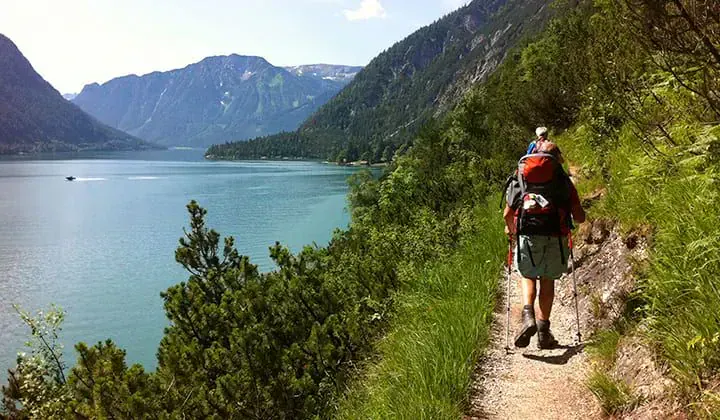 Randonneurs sur sentier au bord d'un lac alpin - Tyrol Autriche