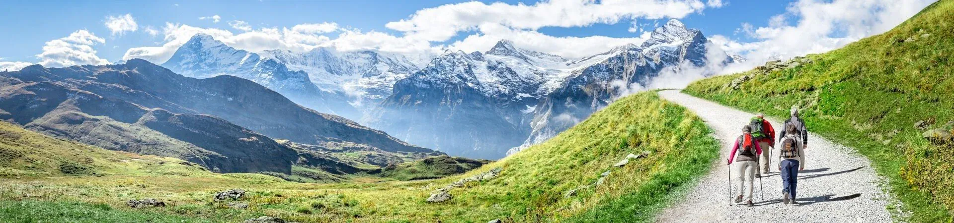 Randonneurs sur sentier face aux sommets enneiges - Alpes suisses