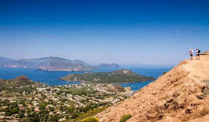 Randonneurs admirant les iles Eoliennes depuis Vulcano - Sicile Italie