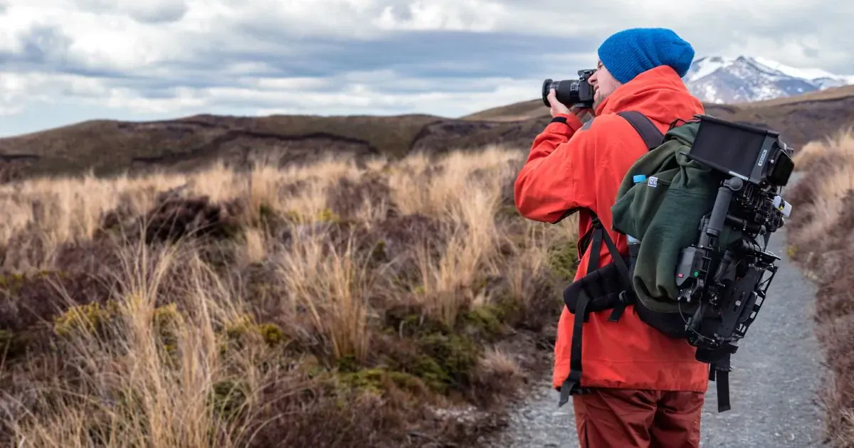 Photographe avec appareil photo en randonnée - Paysage de montagne