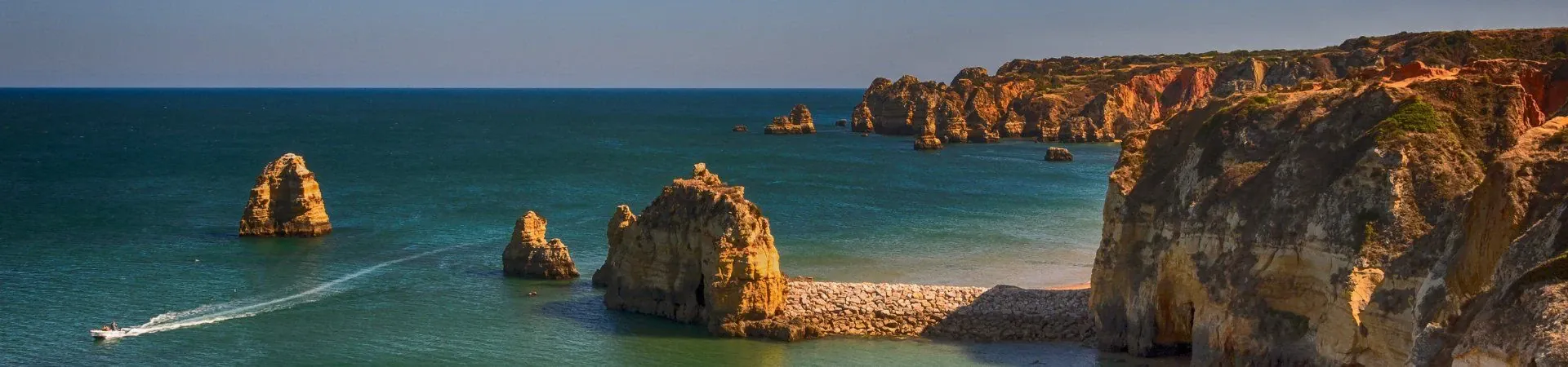 Falaises rocheuses et eaux turquoise avec bateau - Algarve - Portugal