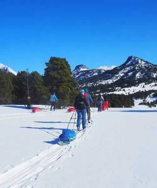 Groupe de ski de randonnée avec pulkas sur plateau enneigé - Pyrénées - France © David Praire