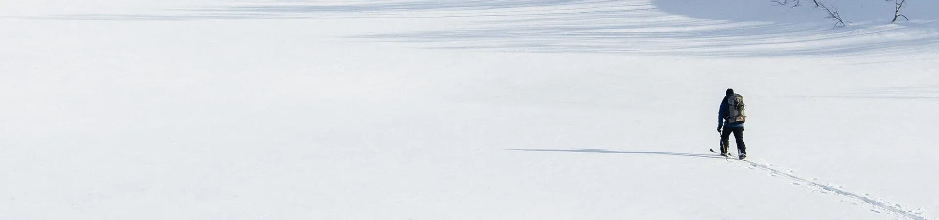 Skieur solitaire traversant une vaste plaine enneigee