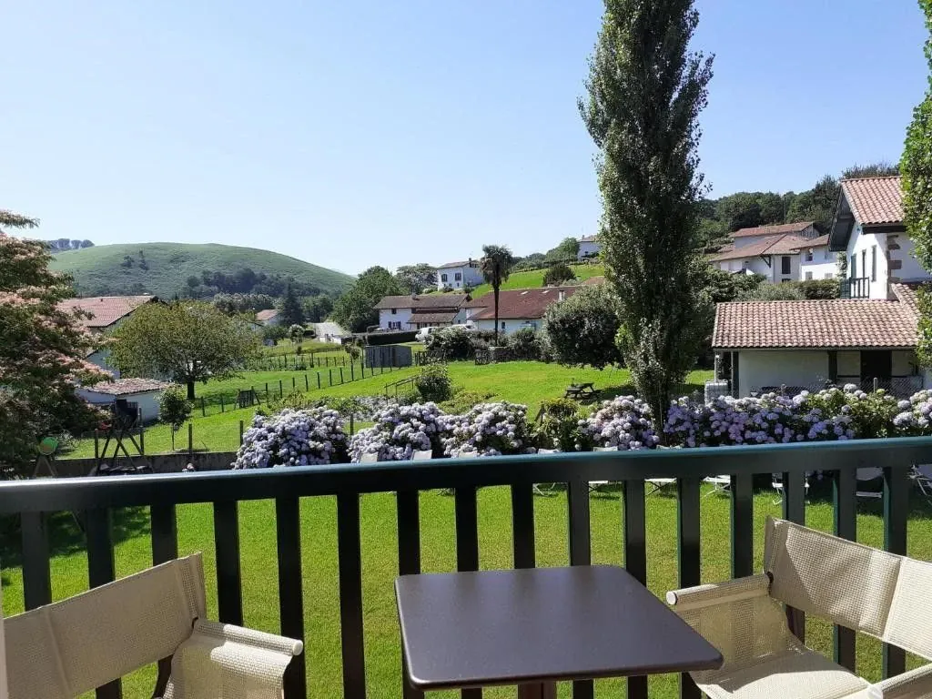 Vue depuis une terrasse sur un village basque et collines verdoyantes - Pays Basque France