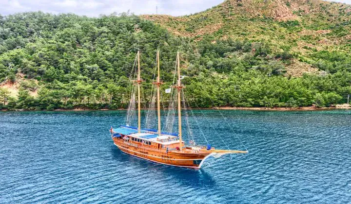 Goelette traditionnelle en bois dans une baie turquoise - Cyclades Grece